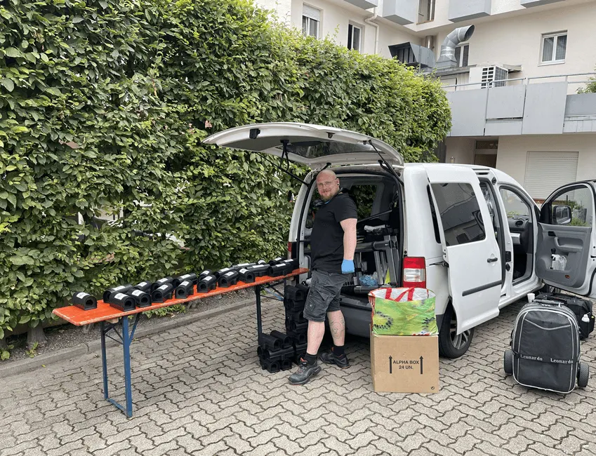 Einsatzfahrzeug mit ausgeklapptem Tisch und aufgereihten Köderstationen vor einem Wohnhaus